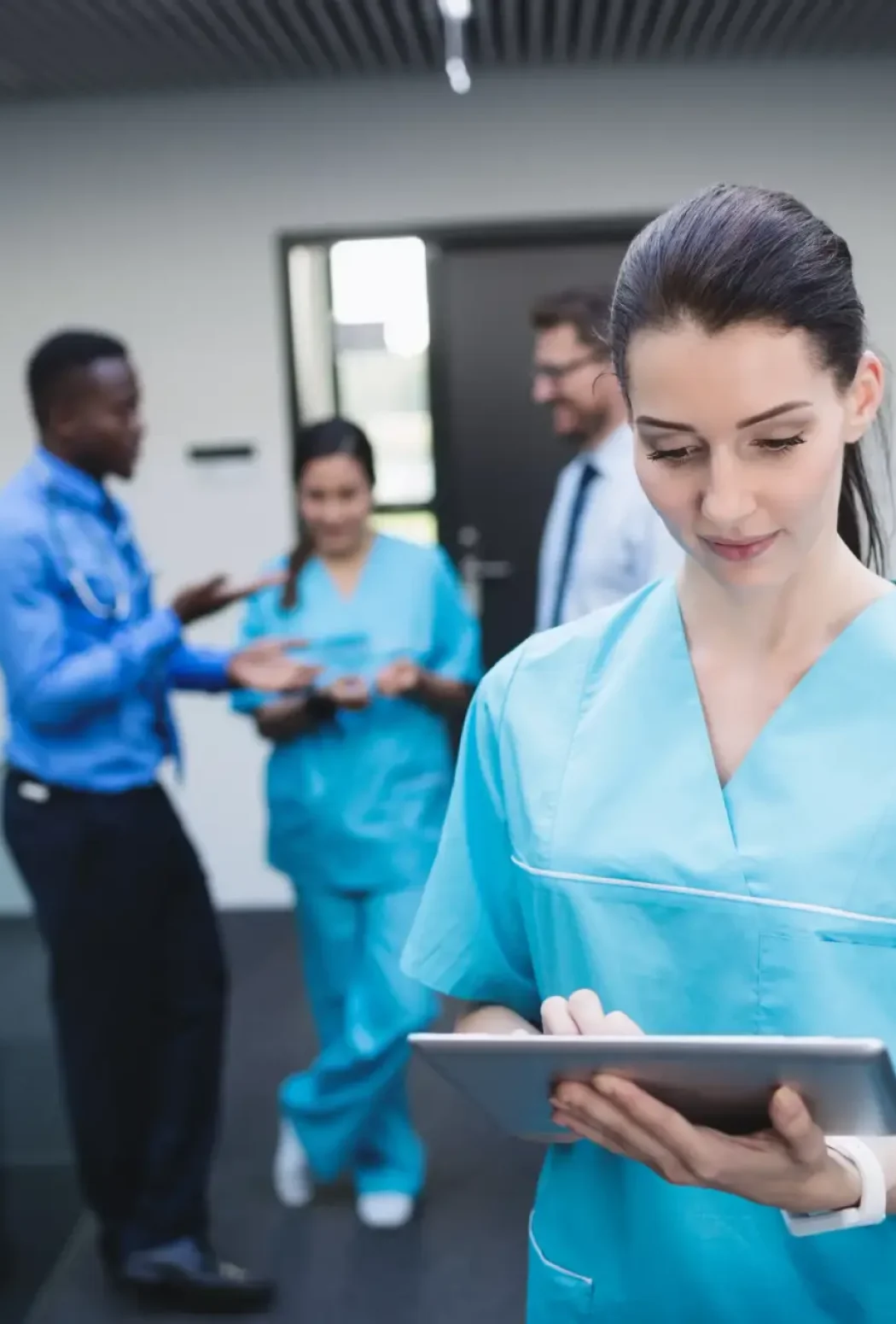 Nurse using a digital tablet in a hospital corridor